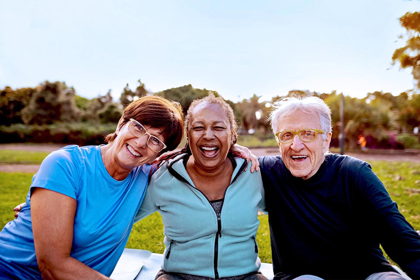 Image of three older friends enjoying each other's company in a park