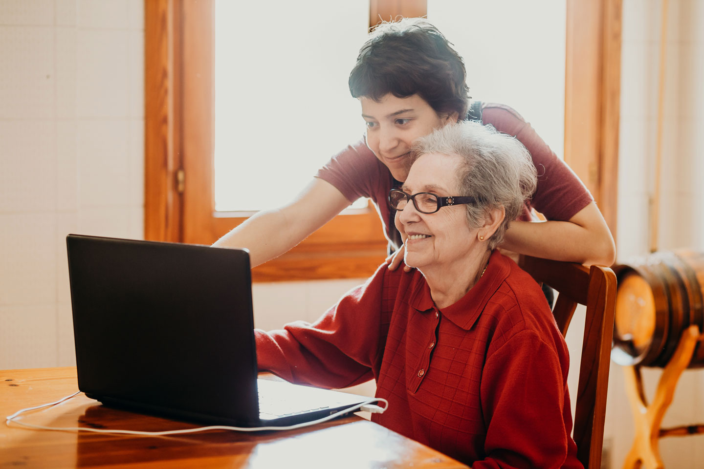 Older woman using laptop with adult daughter 