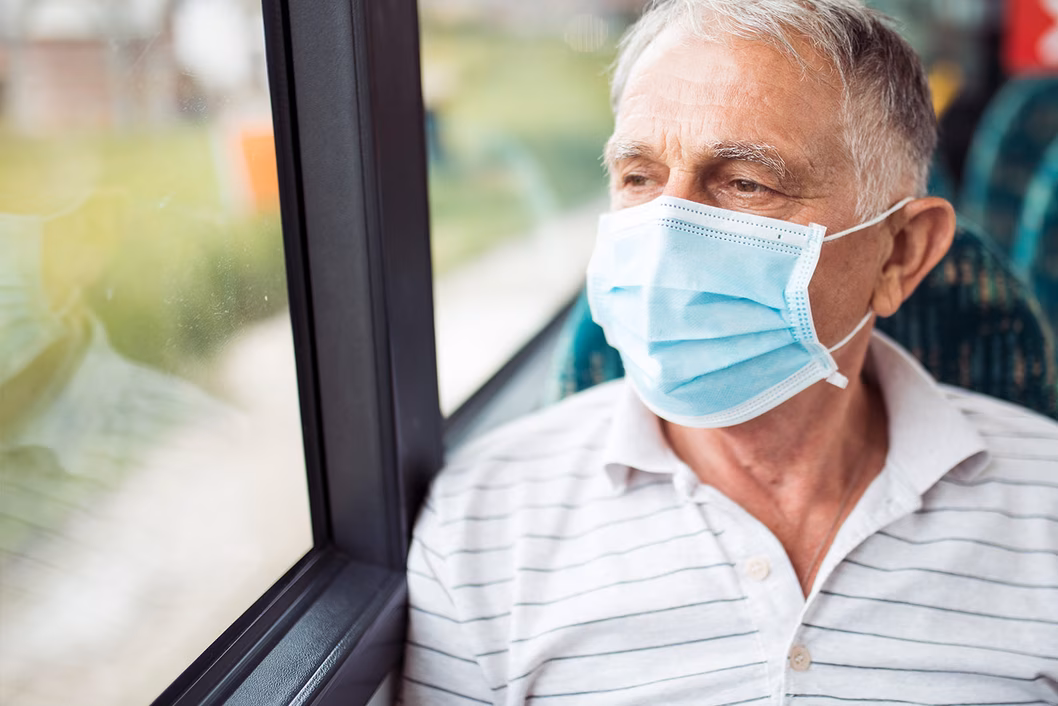 Man on public transport wearing a face mask