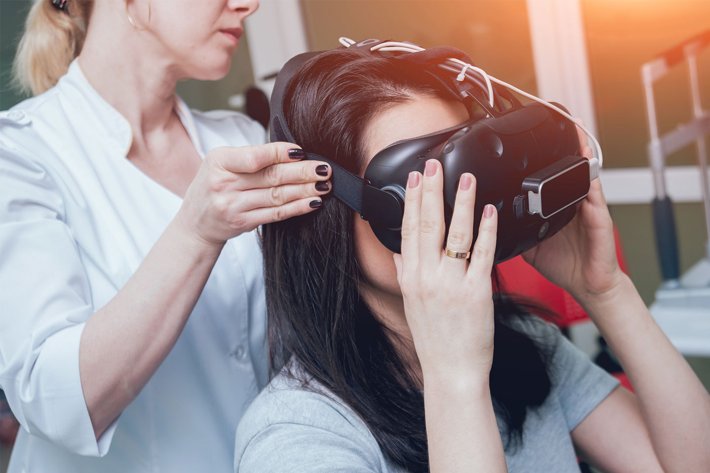 Photo of woman with VR headset being helped by technician