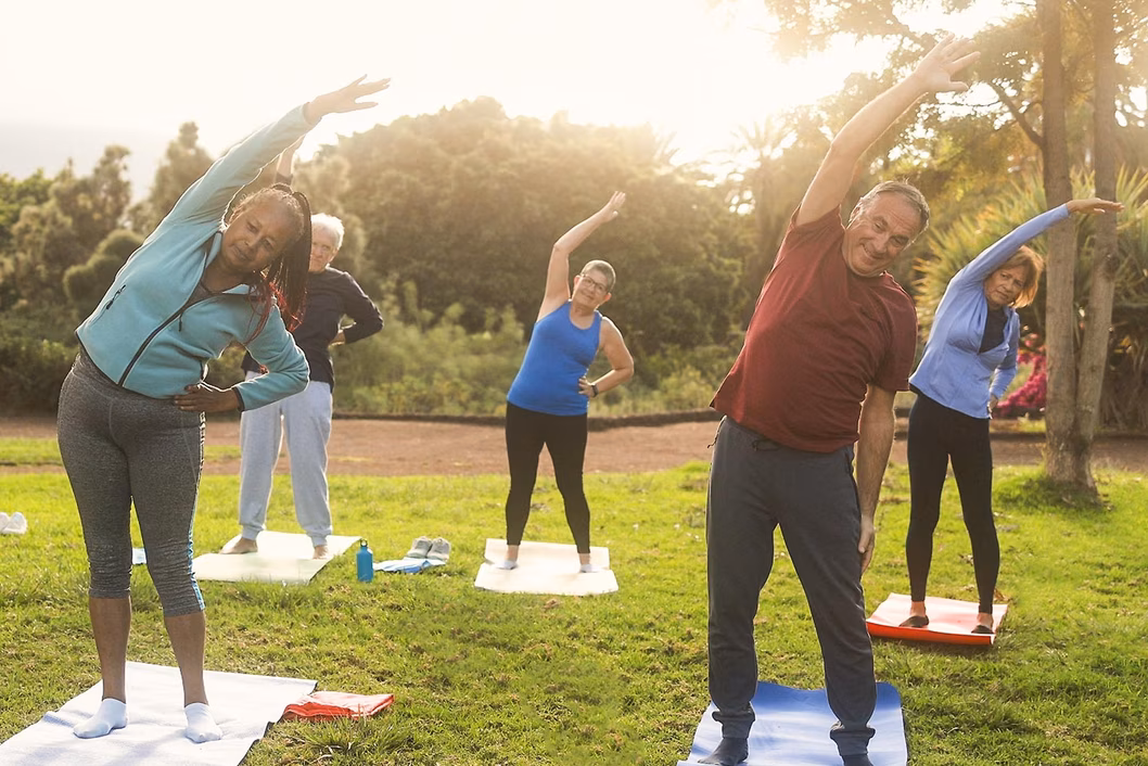 Foto di una classe di fitness di gruppo che fa stretching all'aperto