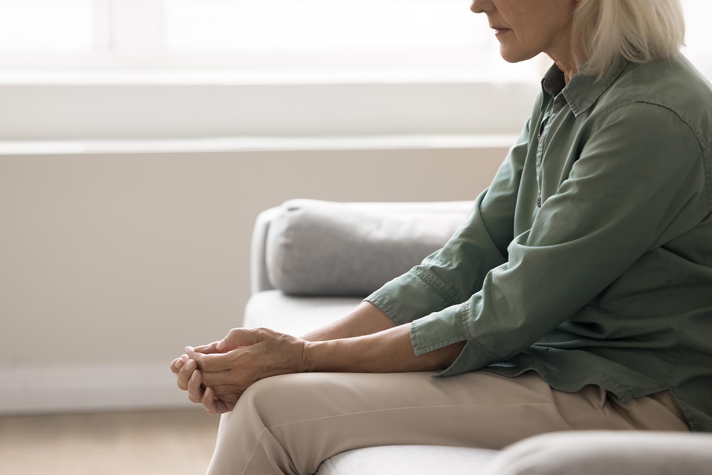 Photo of a woman in a green shirt sitting on a sofa
