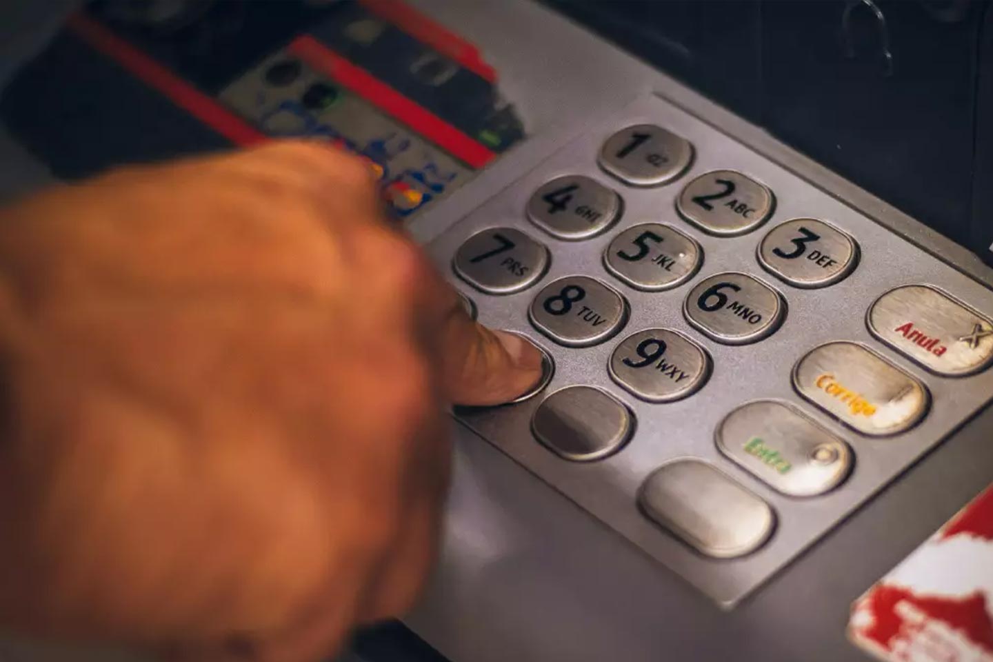 Photo of a finger pressing buttons on an ATM