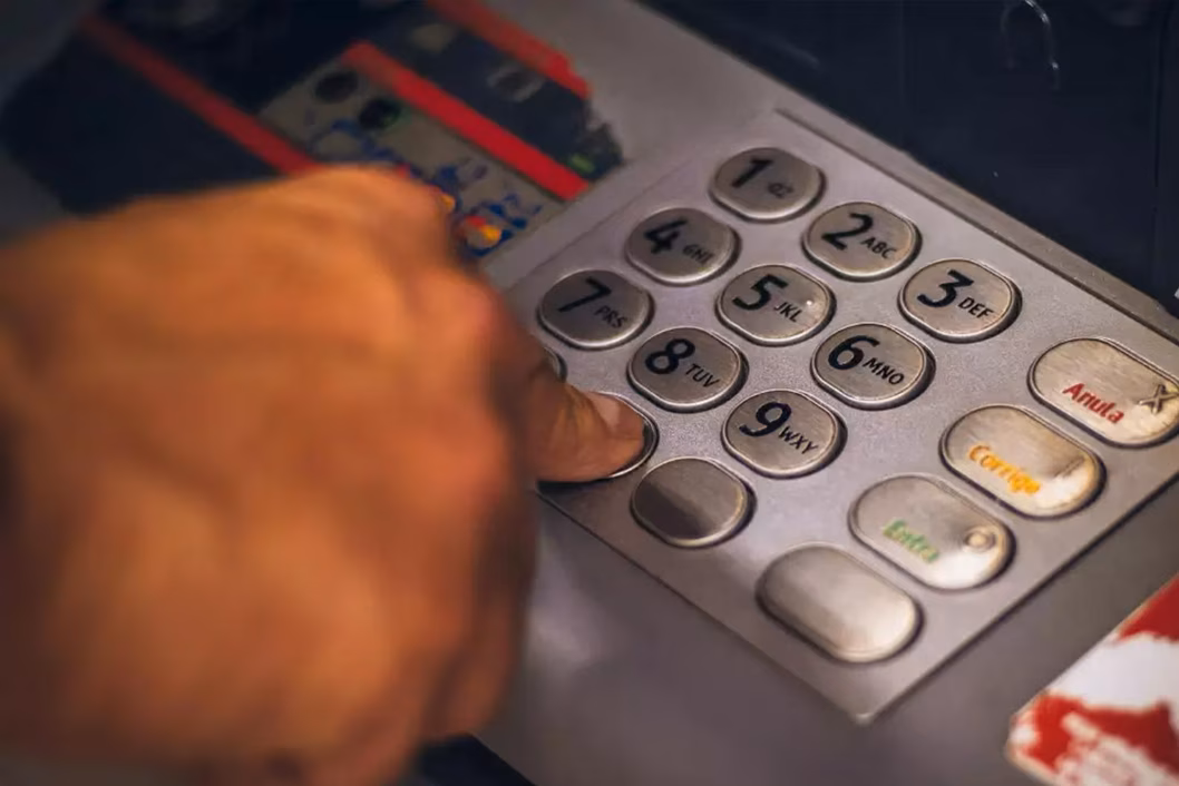 Photo of a finger pressing buttons on an ATM