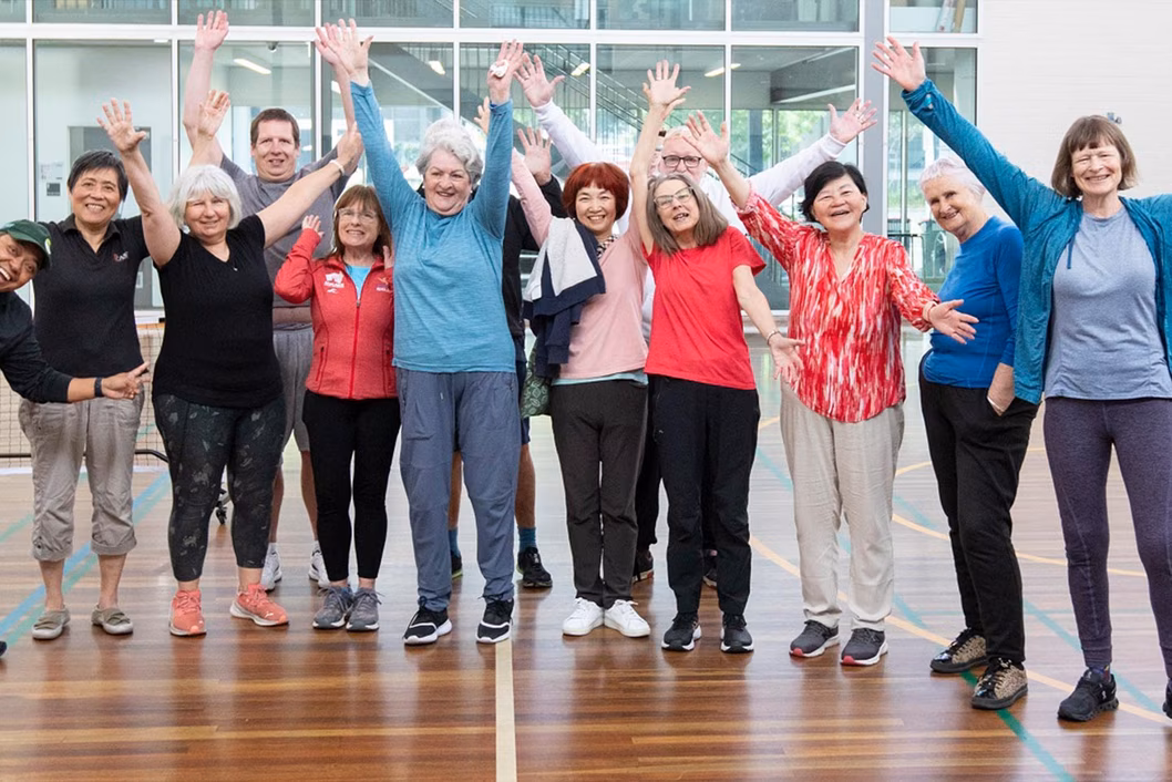Photo of a group of people cheering with their hands in the air
