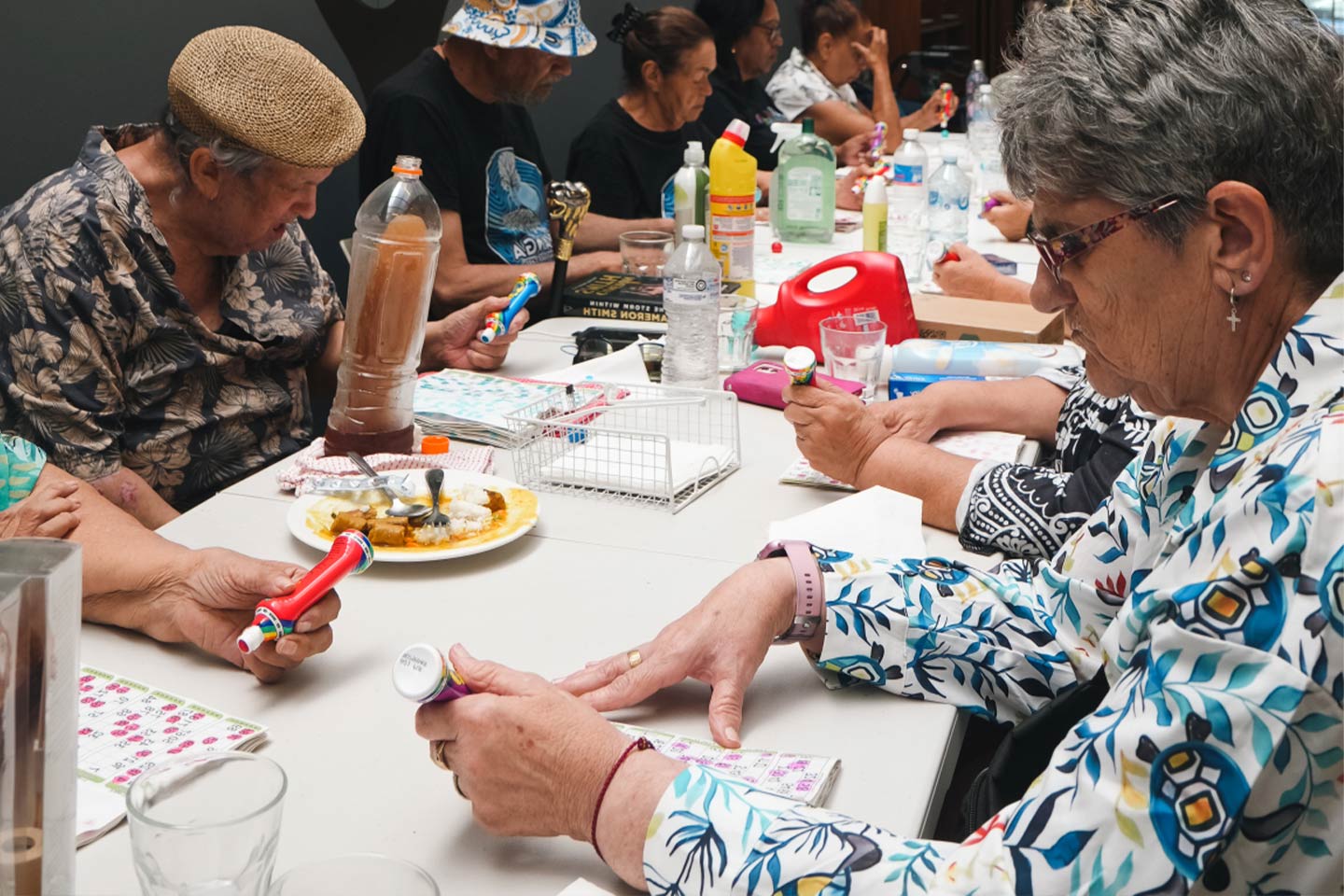 Photo of elders playing bingo at a community table