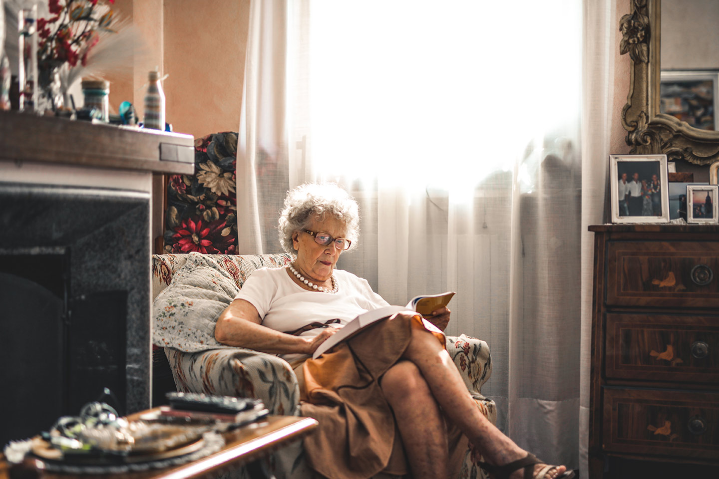 Image of an older woman reading at home