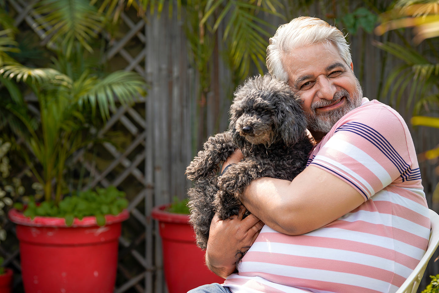 Photo of a man cuddling a fluffy dog