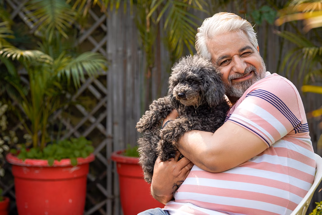 Photo of a man cuddling a fluffy dog