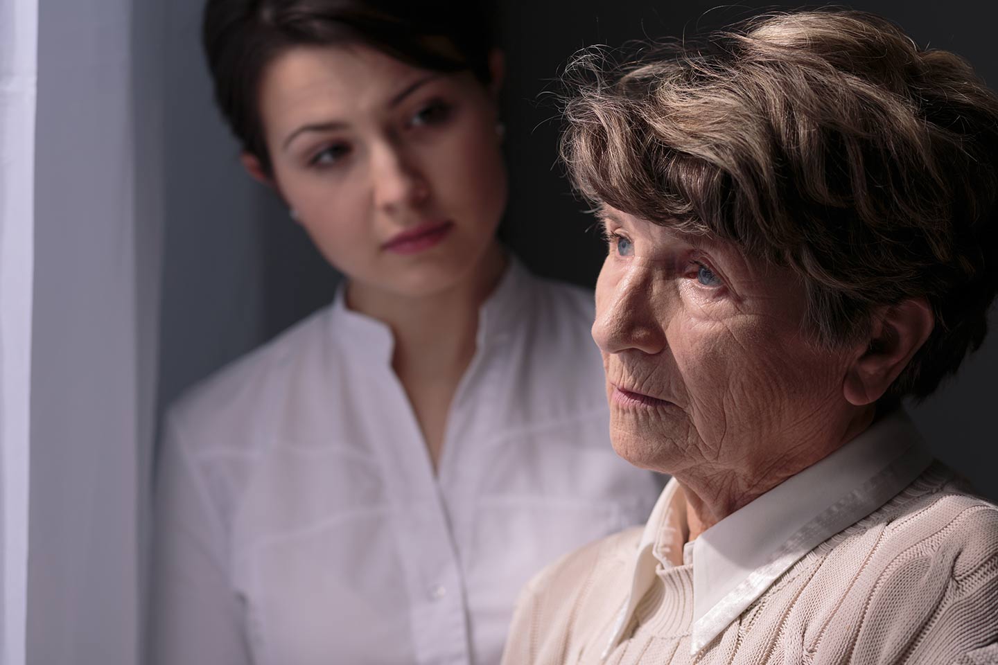 Photo of older woman with younger woman in the background