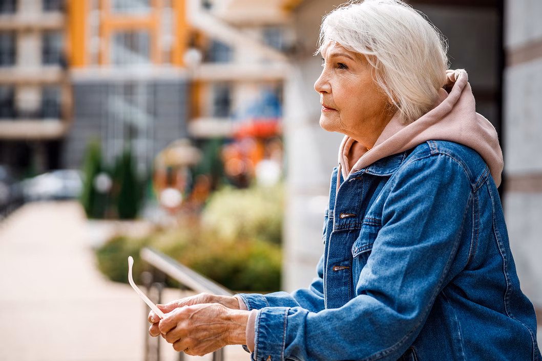 Photo of a women wearing a pink hoodie and denim jacket