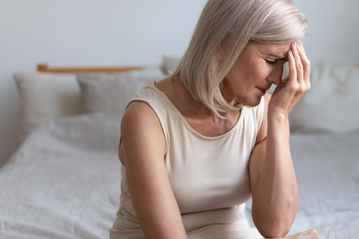 Photo of woman with her hand to her forehead