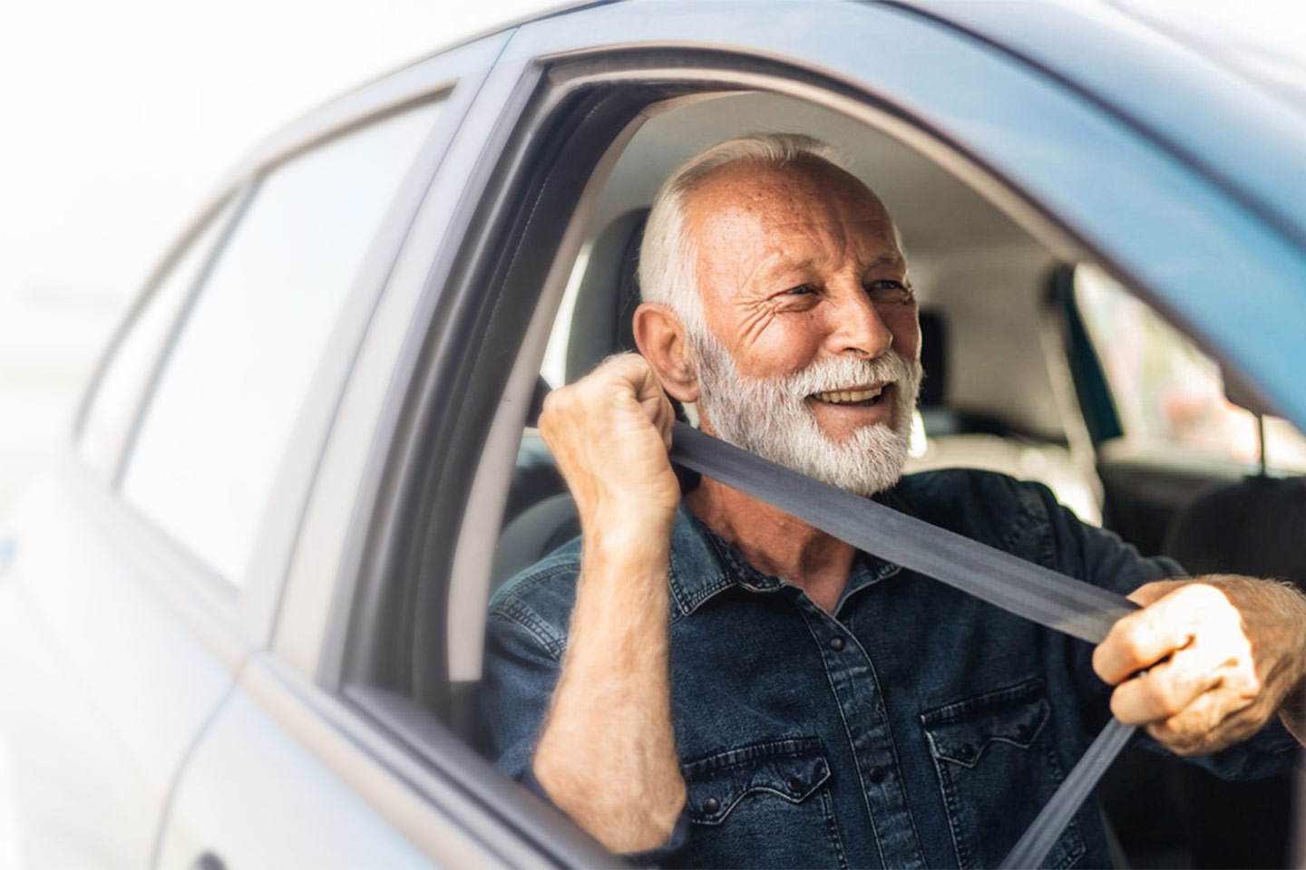 Photo of a happy man putting on his seatbelt