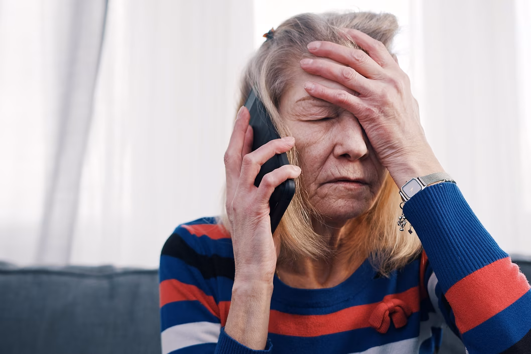 Photo of stressed woman with hand to her forehead