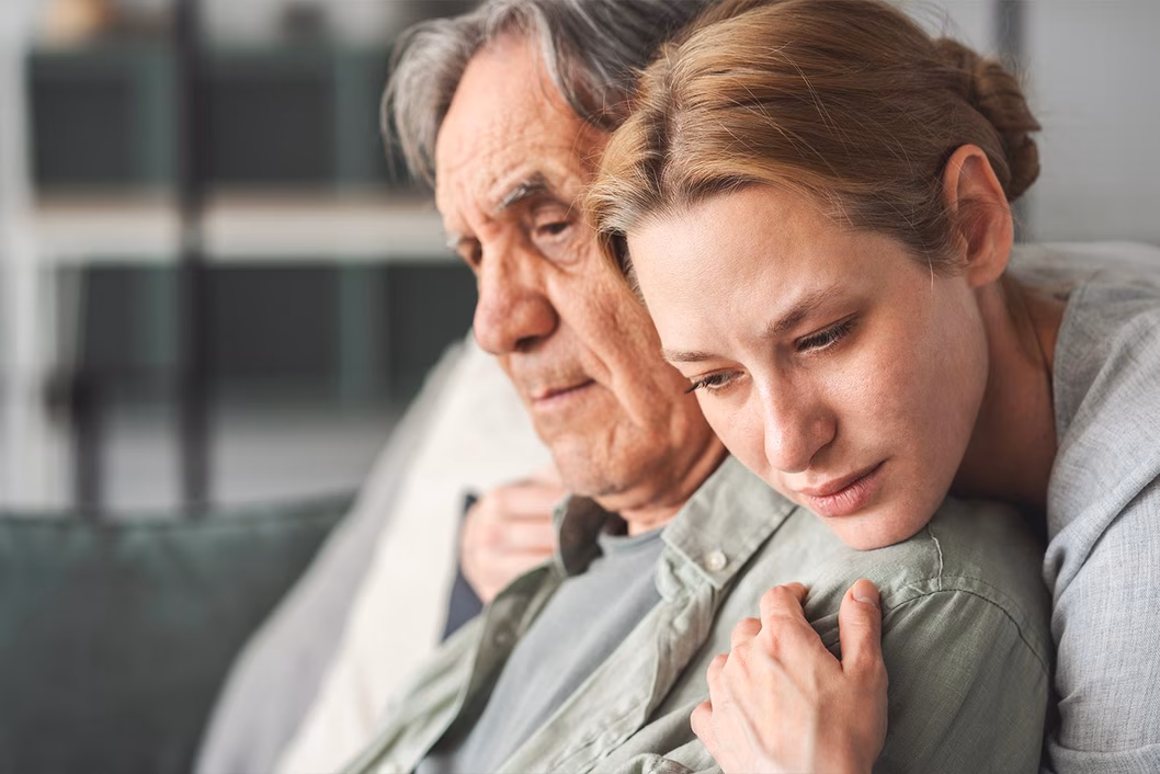 Photo of a young person embracing an older person