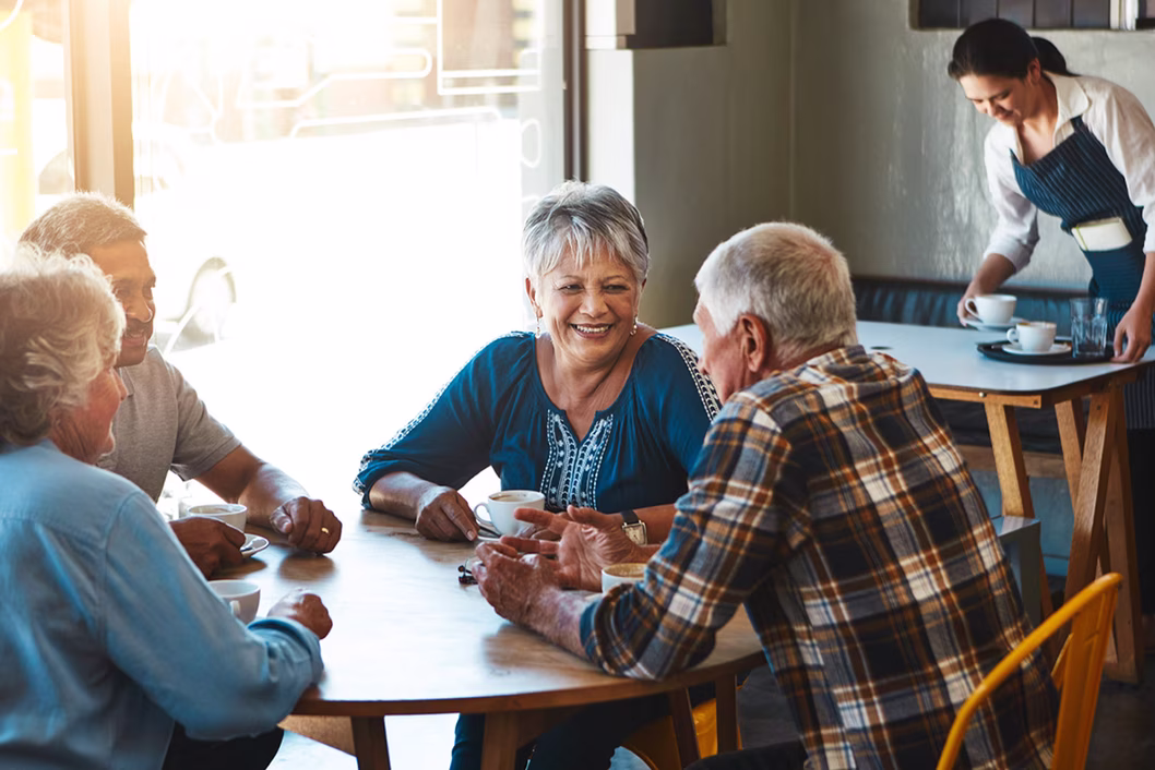 Image of a group of older people having a coffee at a round table
