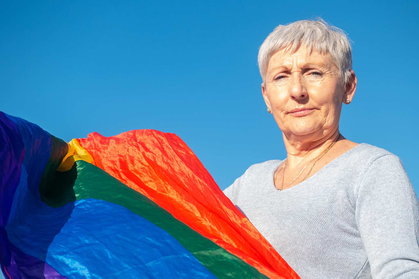 Photo of older woman with rainbow flag