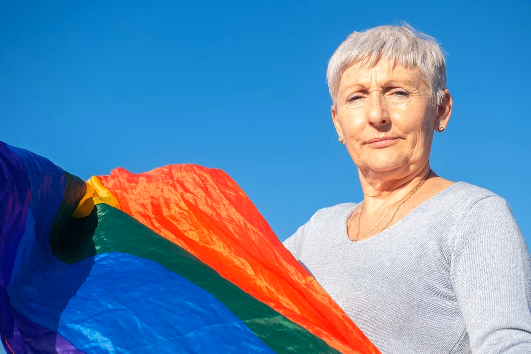 Photo of older woman with rainbow flag