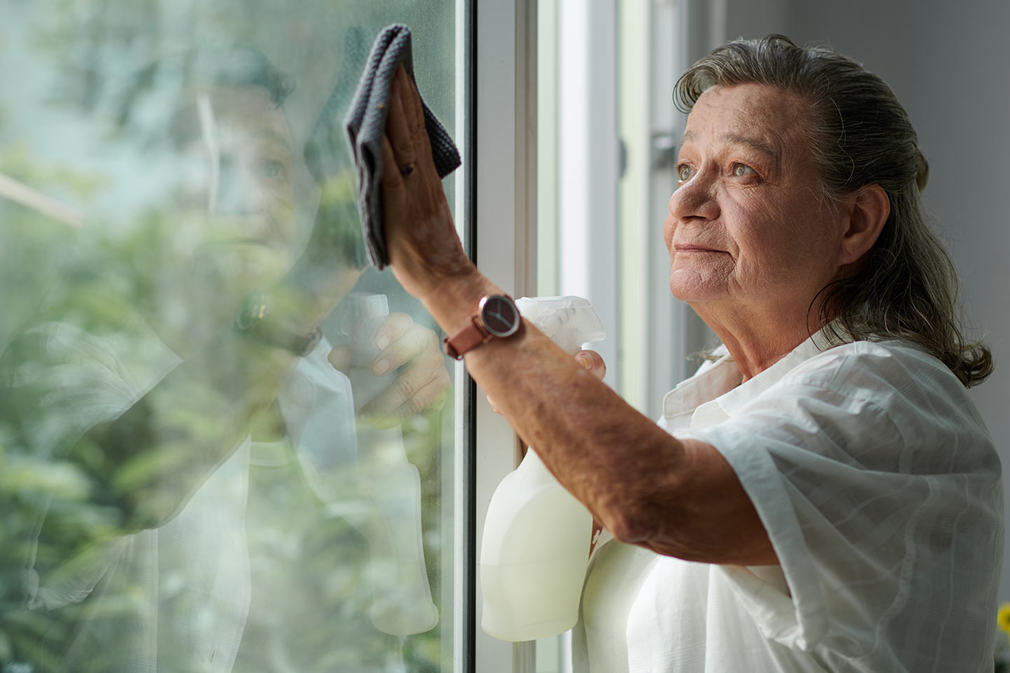 Photo of woman washing a window