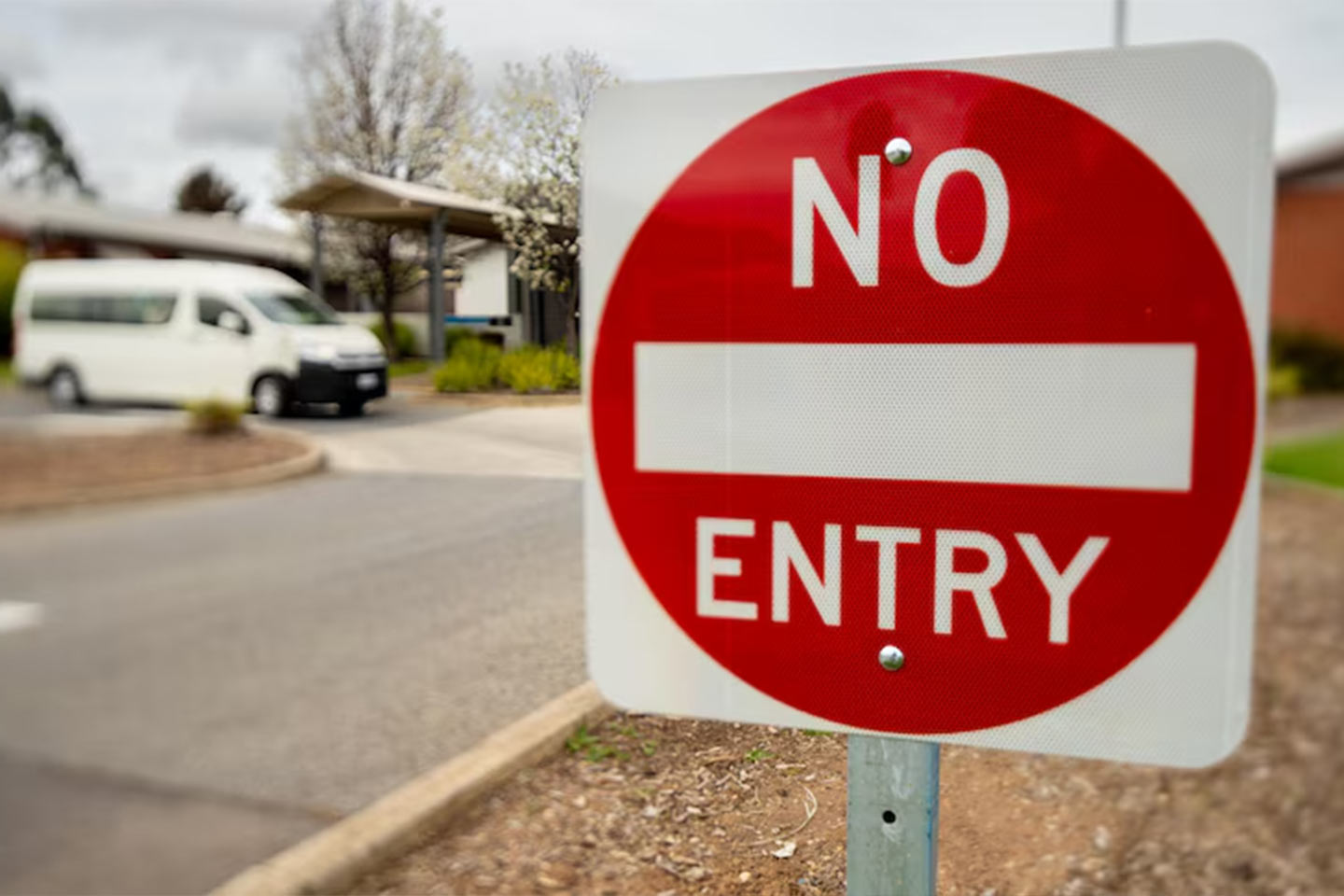 Photo of a no entry sign by a suburban roadside