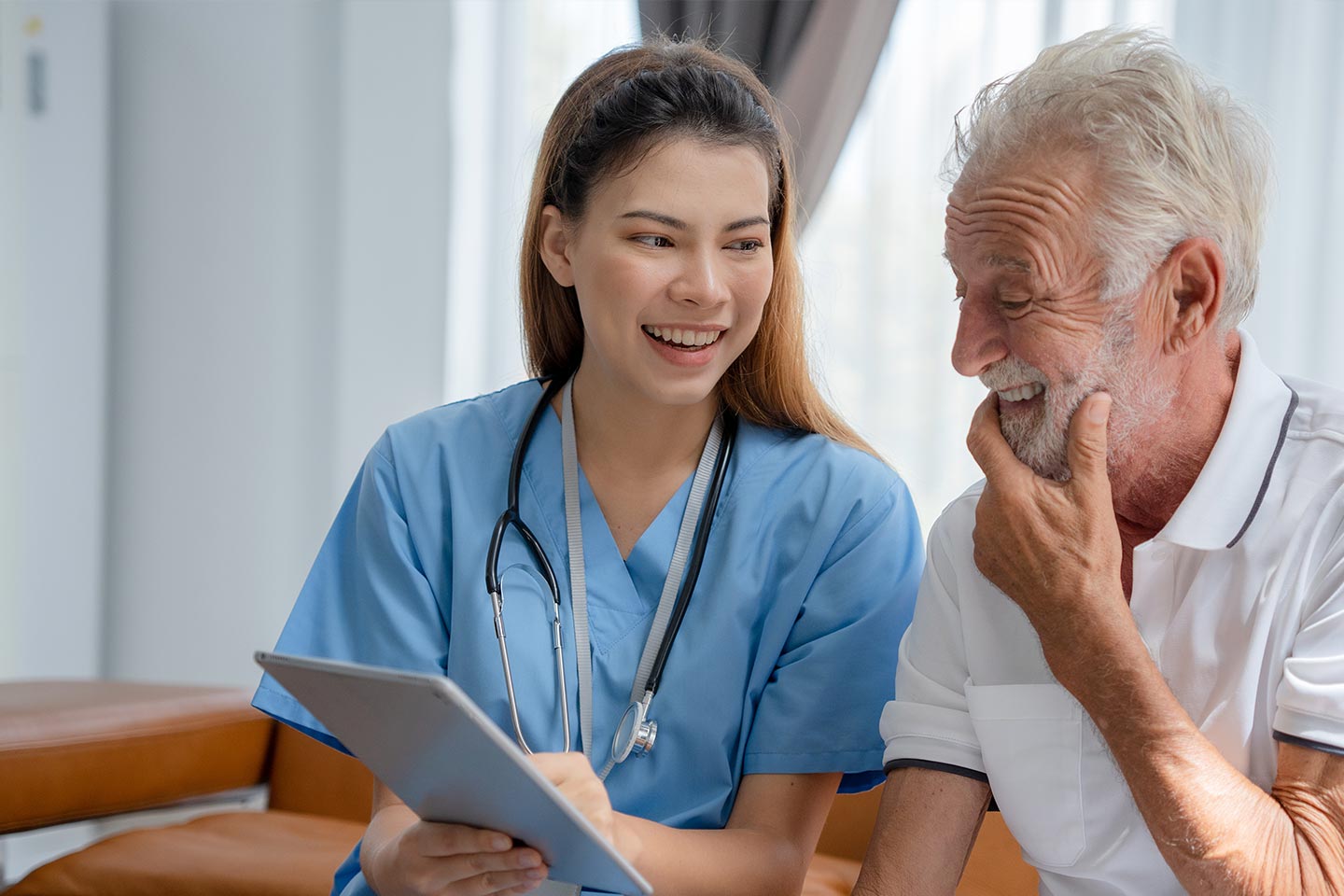 Photo of woman in scrubs discussing something with man