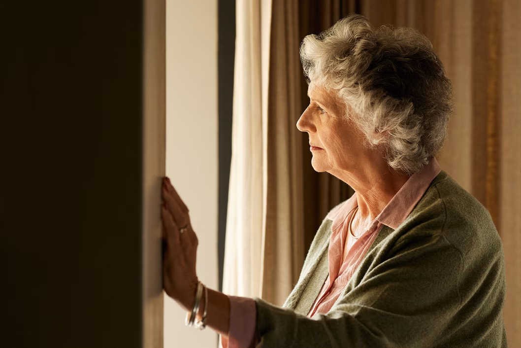 Photo of woman looking through a window