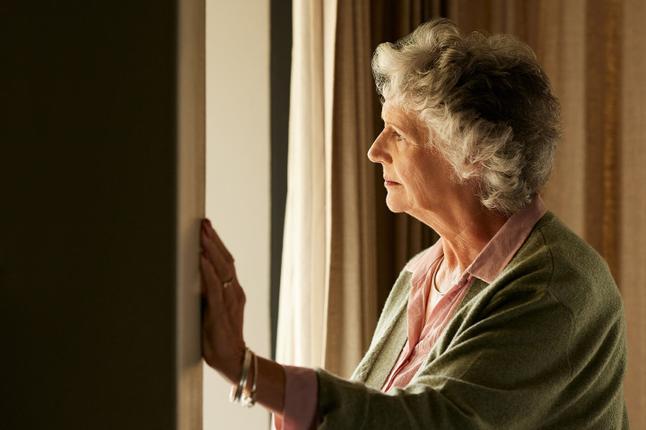 Photo of woman looking through a window
