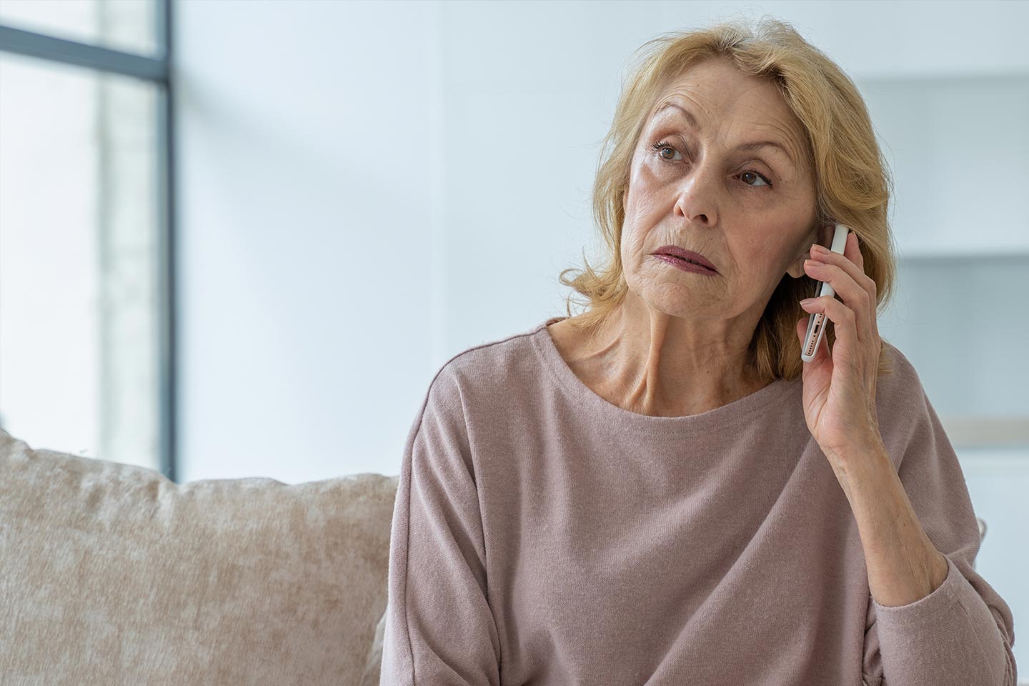 Photo of a woman on the phone wearing a pale heather top