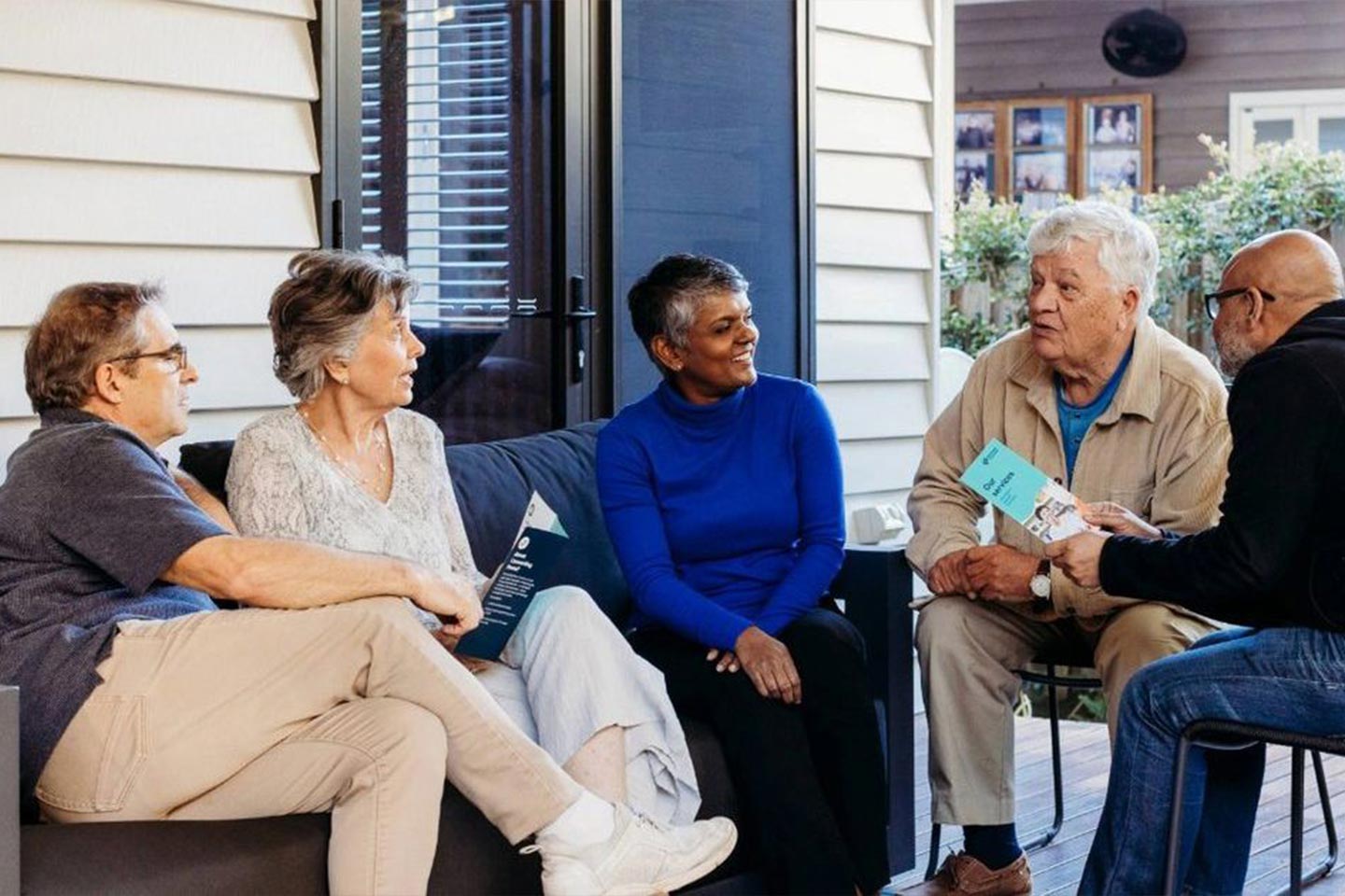 Photo of a group of older people having a meeting on a verandah