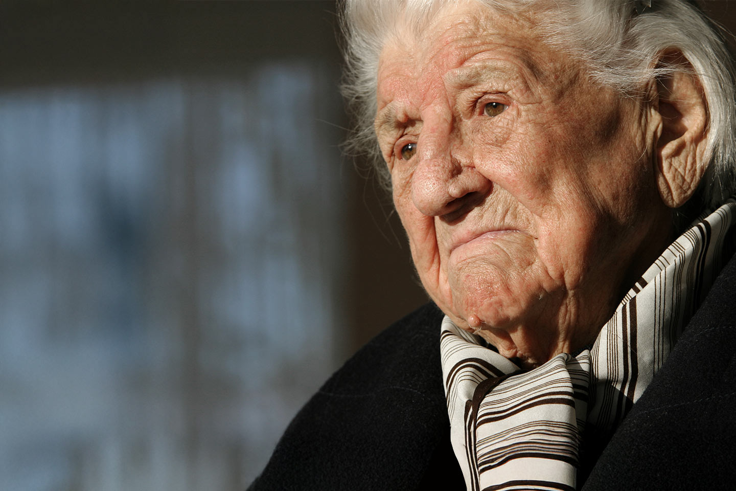 Photo of a person with a striped scarf and black top