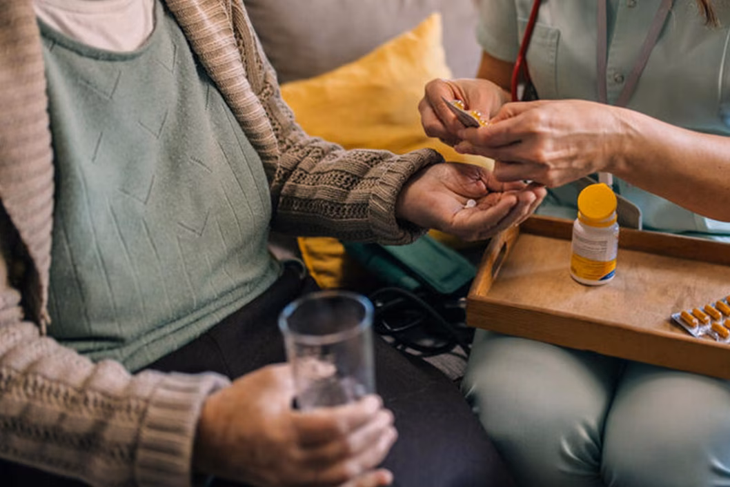 Photo of hands dispensing medicine to someone