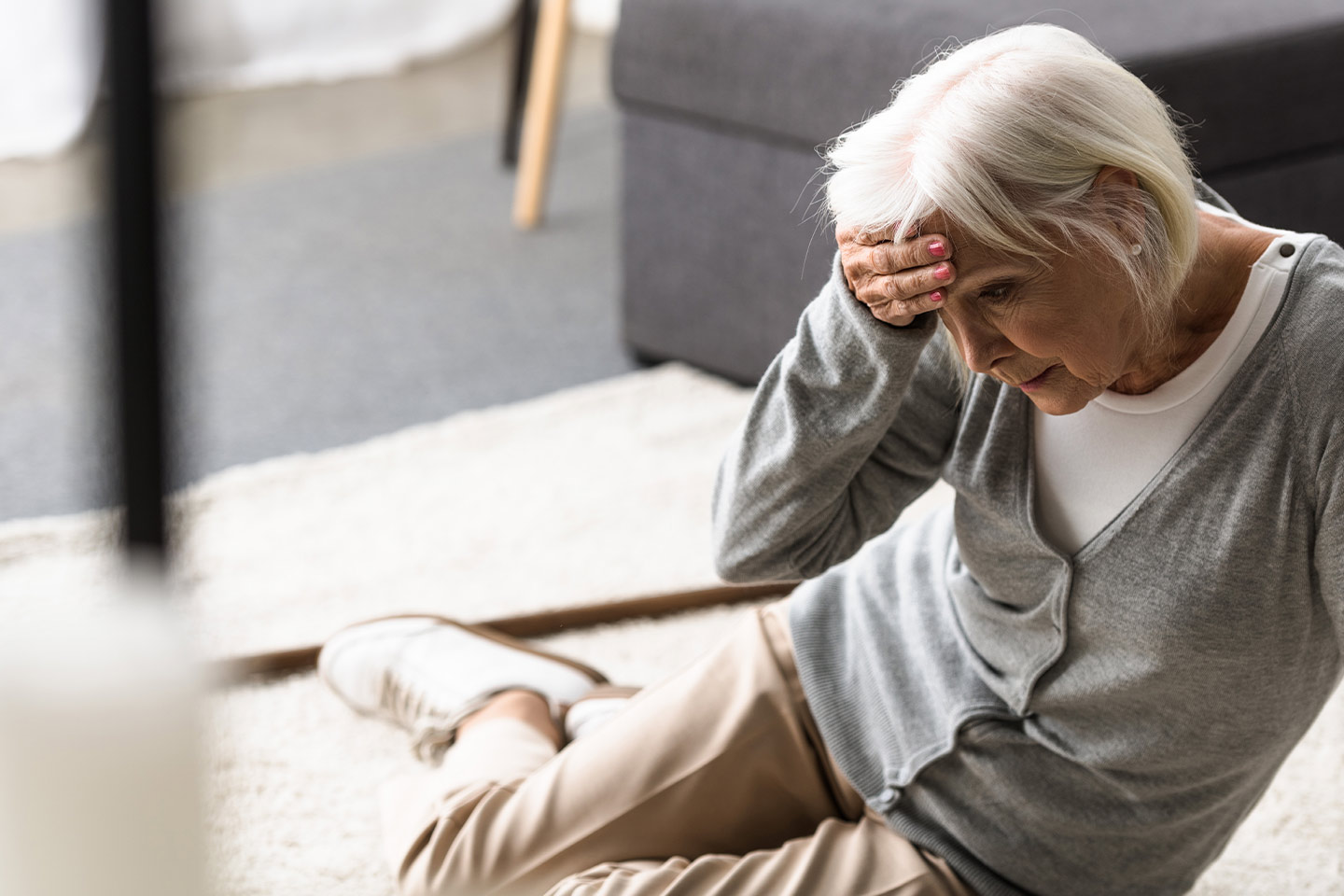Photo of a woman on the ground with her hand on her forehead