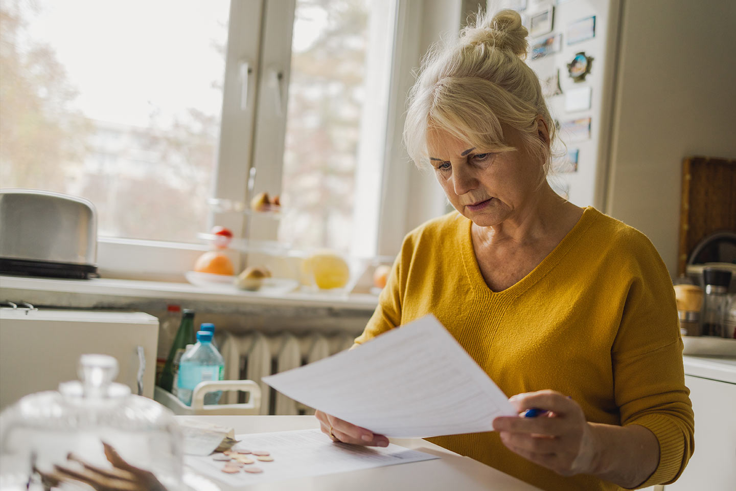 Photo of woman in yellow doing paperwork