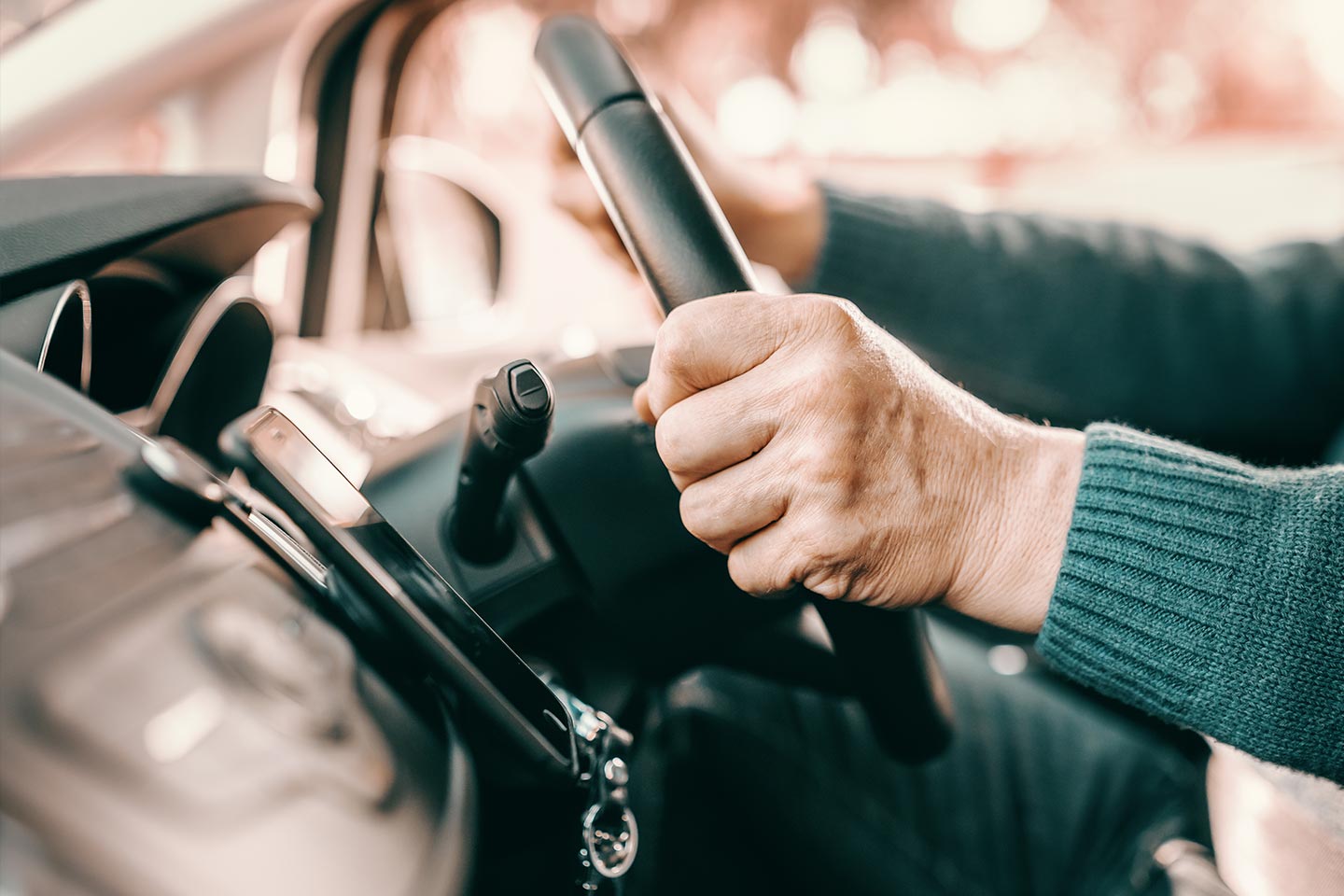 Photo of hands on a car steering wheel