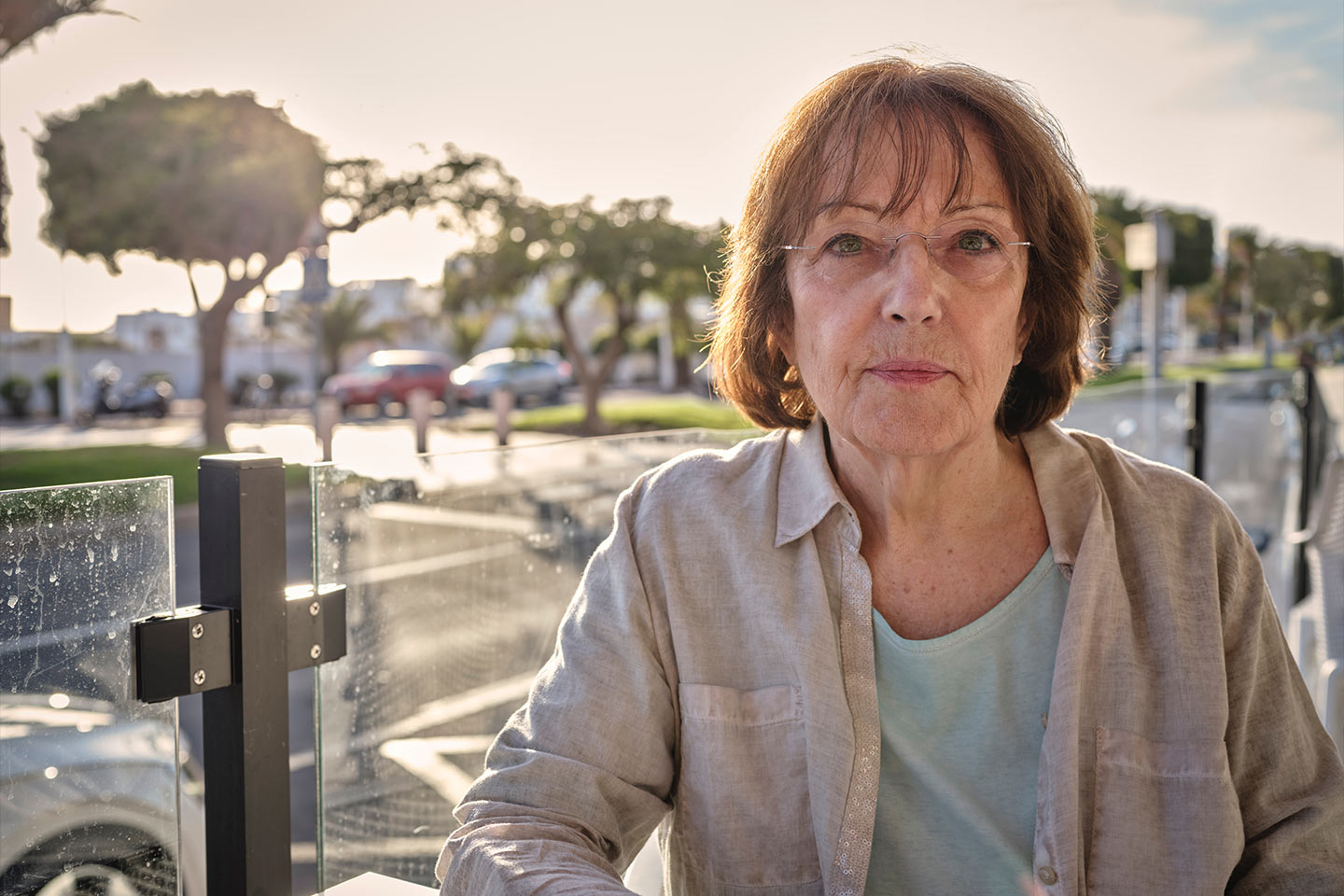 Image of an older woman who is outside and looking directly at the camera
