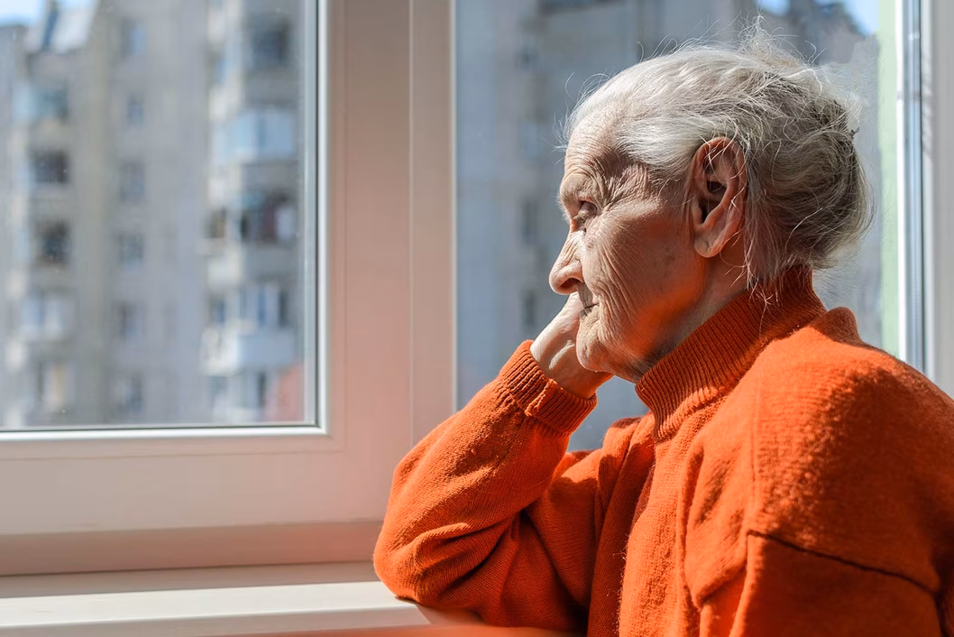 Photo of a senior lady in an orange jumper