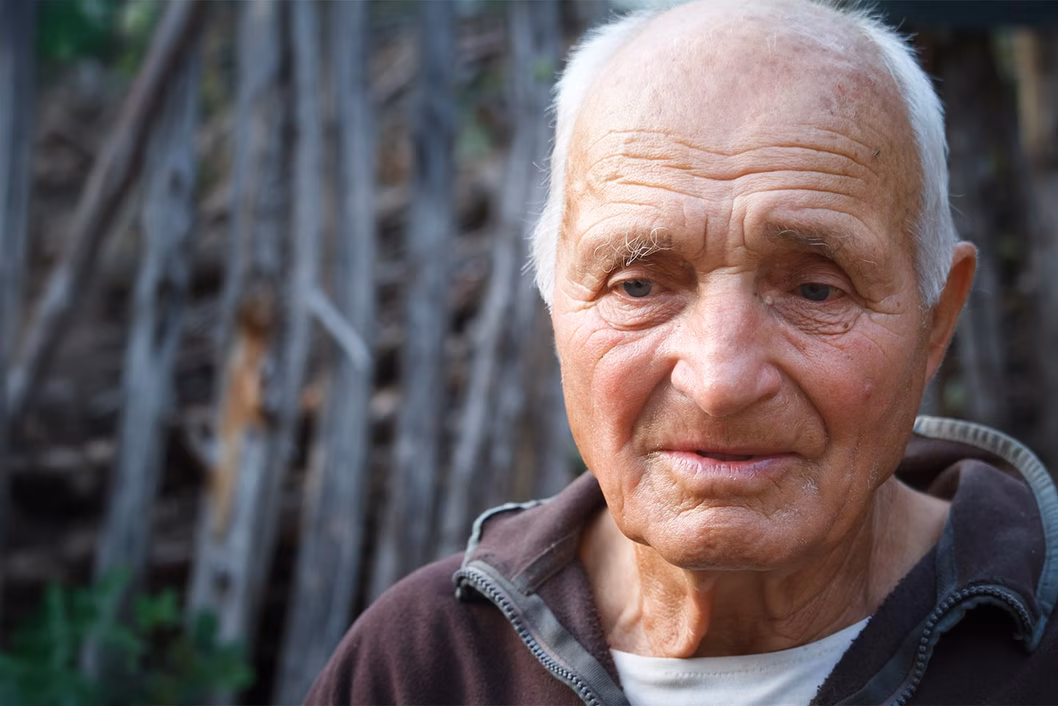 Photo of a sad looking man in a brown jumper