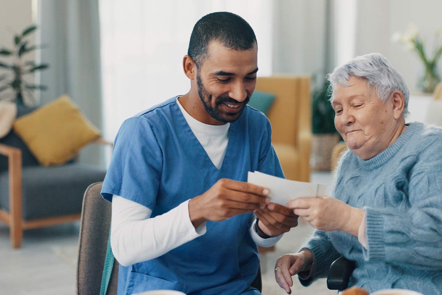 Photo of nurse sharing photos with lady in a blue jumper