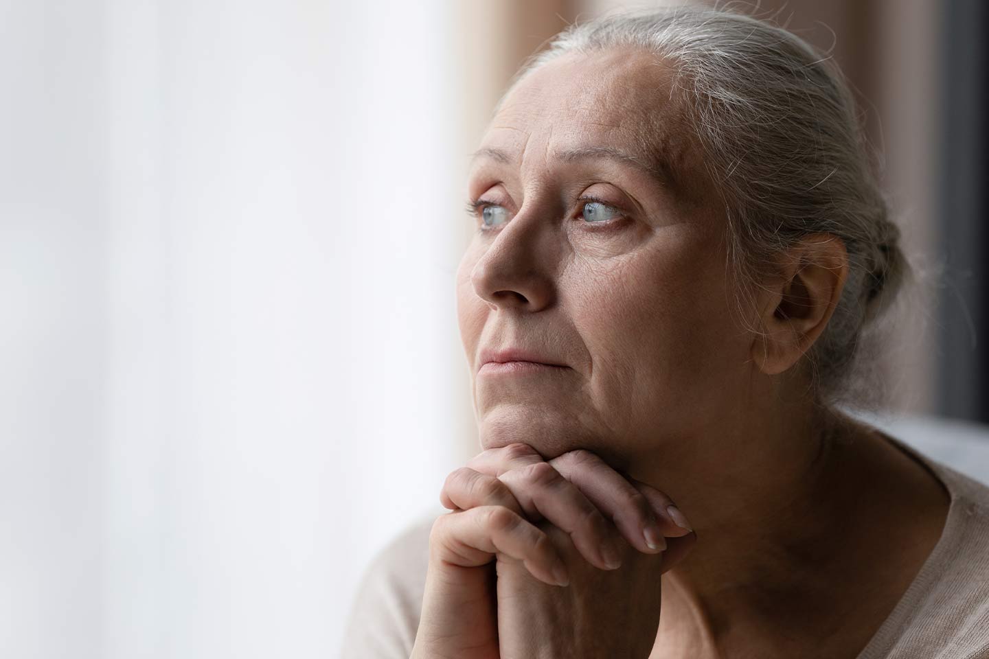Photo of woman with her hair tied back looking pensive