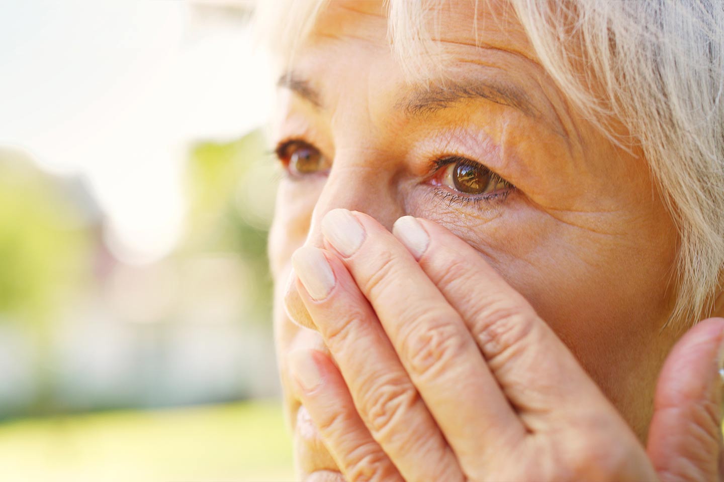 Photo of woman wiping away tear