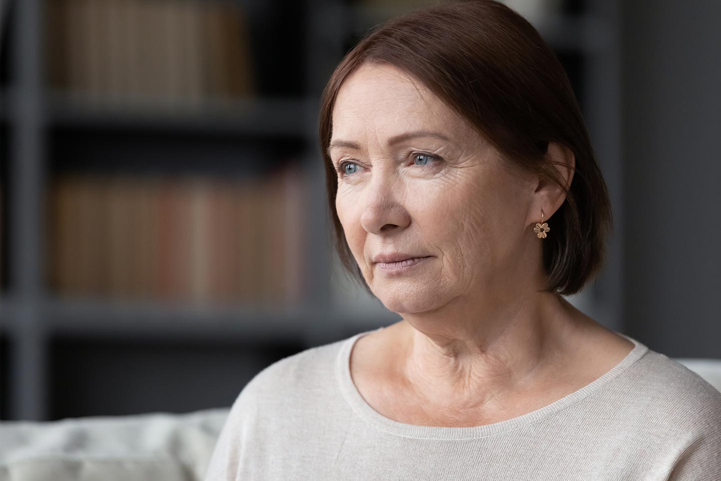 Photo of a woman with an auburn bob looking pensive