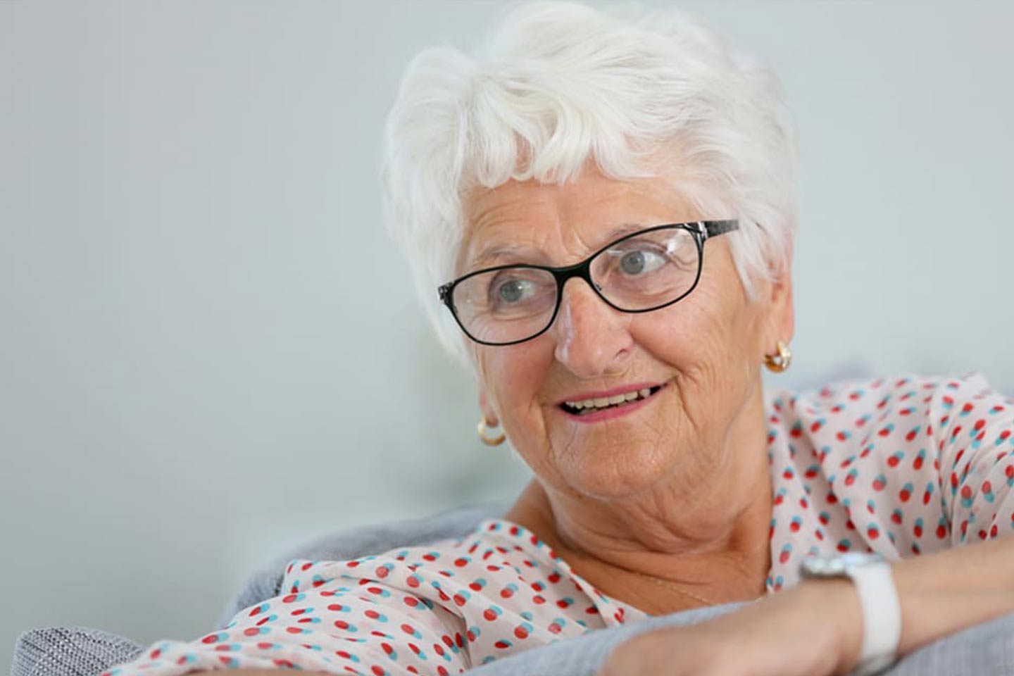 Photo of a white haired woman wearing black framed glasses