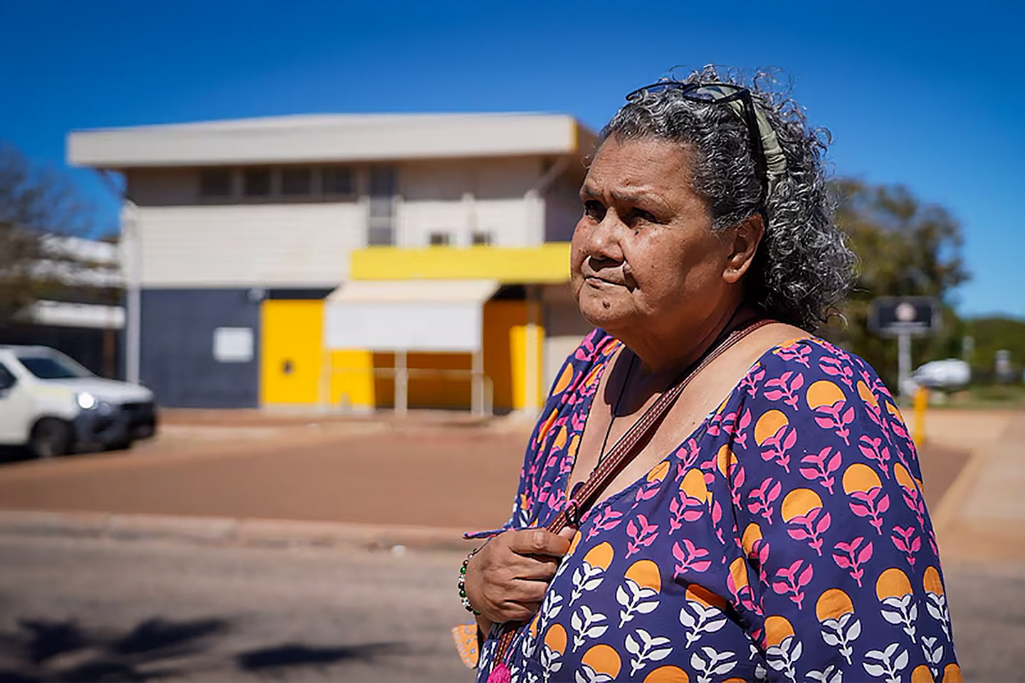 Photo of a woman wearing a purple dress outside a building