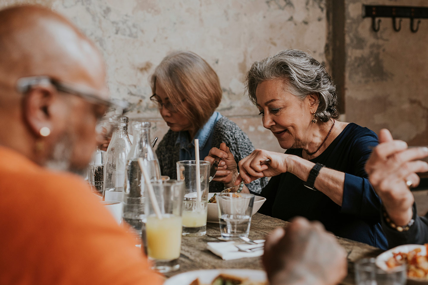 Photo of people eating together in rustic surrounds