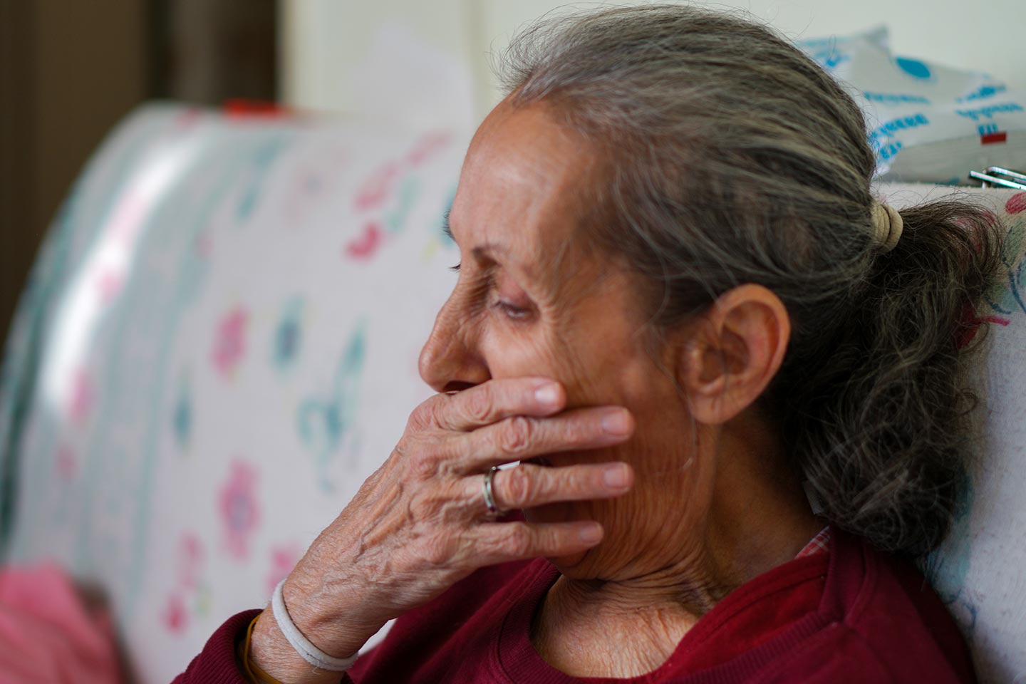 Photo of woman in a burgundy top with her hand over her mouth
