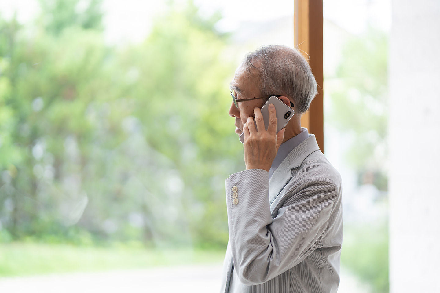 Older Asian man holding a mobile phone to his ear