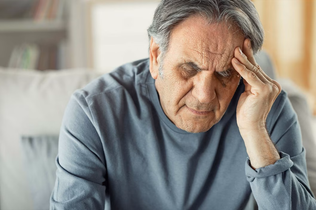 Photo of a man with his hand to his head