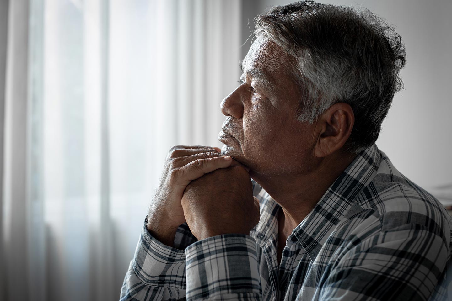 Photo of a pensive man in a plaid shirt