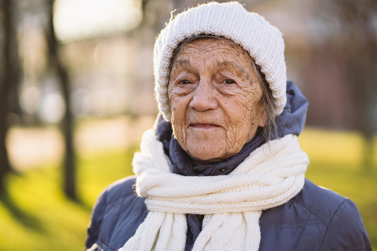 Image of an older woman wearing a knitted beanie and scarf