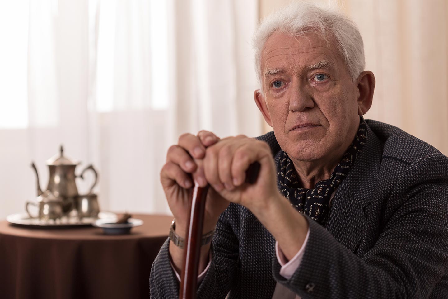 Photo of a man resting his hands on his walking stick